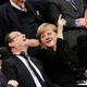 Angela Merkel pointing at the glass dome of the German Reichstag.